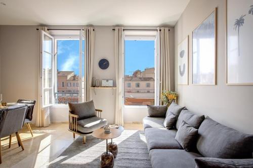 un salon avec un canapé et deux fenêtres dans l'établissement Magnifique 4 pièces Forville - Proche Palais des Festivals, à Cannes