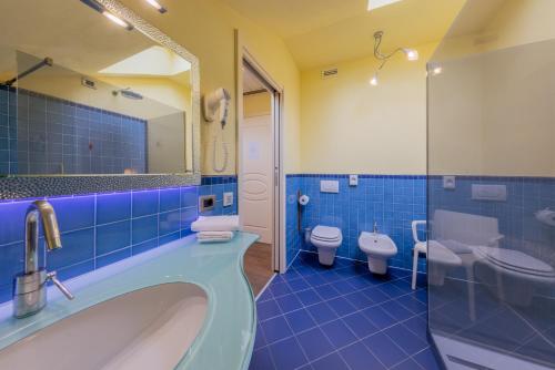 a bathroom with two toilets and a tub and a sink at La Darsena Boutique Hotel & Restaurant in Tremezzo