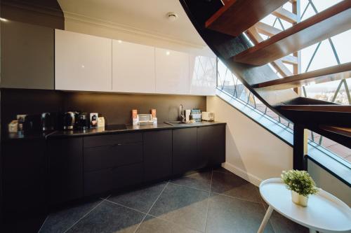 a kitchen with black and white cabinets and a table at Norweska Dolina Family&Pet-friendly Resort in Szklarska Poręba
