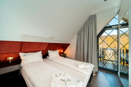 two beds in a room with a large window at Norweska Dolina Family&Pet-friendly Resort in Szklarska Poręba