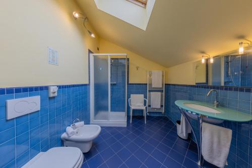 a blue tiled bathroom with a toilet and a sink at La Darsena Boutique Hotel & Restaurant in Tremezzo