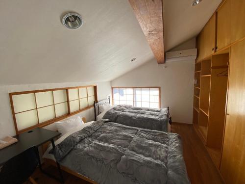 a bedroom with two beds and a desk in it at kakayama hutte in Muraoka