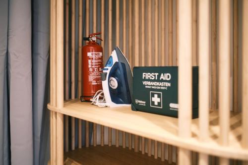 a shelf with a first aid box and a fire extinguisher at Modern und Gemütlich Augsburg Center Kongress in Augsburg