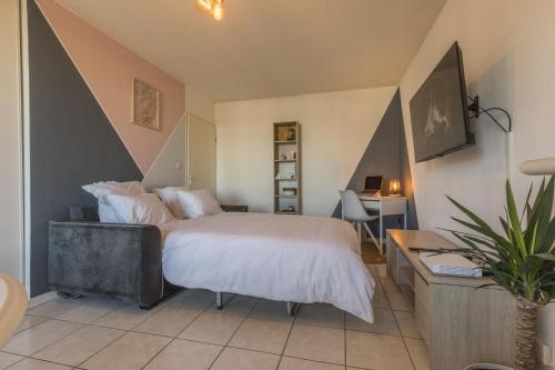 a bedroom with a large bed and a desk with a desk at Spacieux proche aéroport et airbus in Toulouse