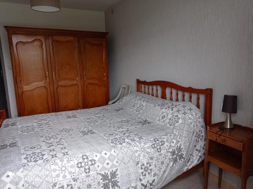 um quarto com uma cama e um armário de madeira em Appartement em Laurac-en-Vivarais