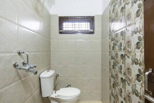 a small bathroom with a toilet and a window at 3BR Apartment by B-Town stays in Dehradun