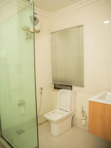 a bathroom with a toilet and a glass shower at Cecilia Homes in Lekki