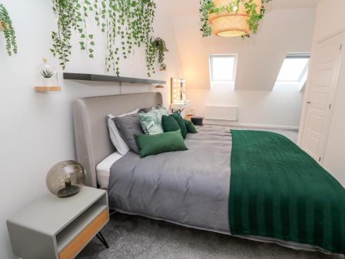 1 dormitorio con 1 cama grande con almohadas verdes en 20 Bishops Way, en Falmouth