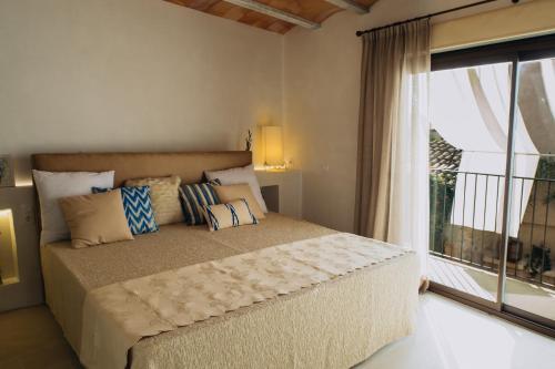 ein Schlafzimmer mit einem Bett und einem großen Fenster in der Unterkunft Can Solaies in Sant Llorenç des Cardassar