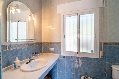 a bathroom with a sink and a mirror and a toilet at Casa Hyam in Alcaucín