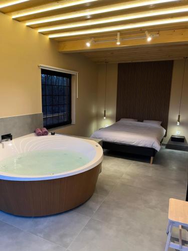 a large bath tub in a room with a bed at Chado Belgrade in Belgrade