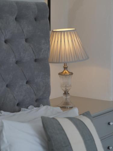 een lamp op een tafel naast een bed bij The Mount in Bideford