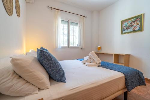 ein Schlafzimmer mit einem Bett mit Kissen und einem Fenster in der Unterkunft Casa Hyam in Alcaucín