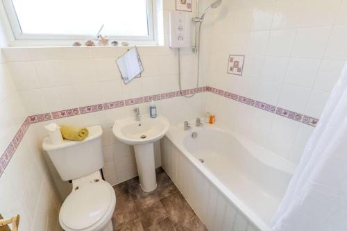 a bathroom with a toilet and a tub and a sink at Tiger House Stevenage 5 Bed 4 Bath Group Bookings in Stevenage