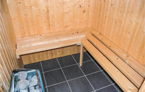 a wooden sauna with a bench and a trash can at Holiday Home Pilemose Sydals in Skovby