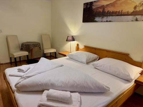 a bedroom with two beds with white sheets and two chairs at Familienfreundliche Ferienwohnung im schönen Thierseetal, FeWo 16 in Thiersee