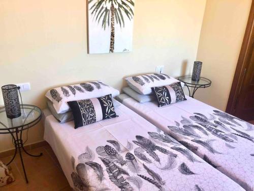2 Betten in einem Zimmer mit 2 Glastischen in der Unterkunft Casita Tranquila in Almería