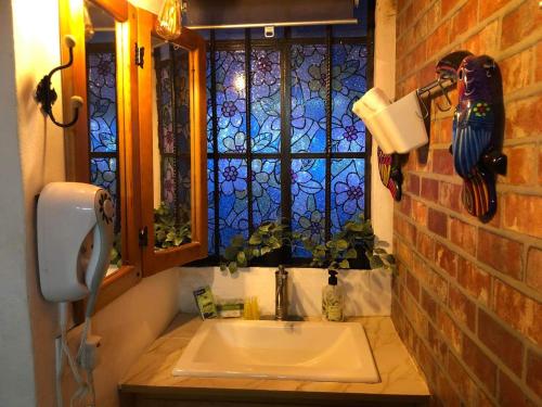 a bathroom with a sink and a window at La Adornada Orquidea in Taxco de Alarcón