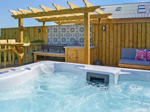 a hot tub in a backyard with a pergola at Ladybird in Boston