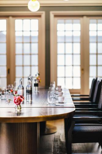 a table in a room with chairs and a table sidx sidx sidx at The Dylan Amsterdam - The Leading Hotels of the World in Amsterdam
