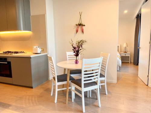 a kitchen and dining room with a table and chairs at Skygarden On The Glen in Glen Waverley