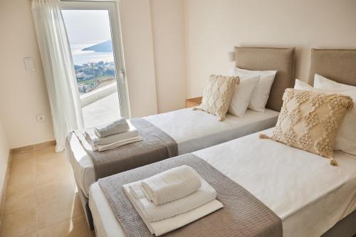 2 camas en una habitación con vistas al océano en Athens Riviera Villa en Anavissos