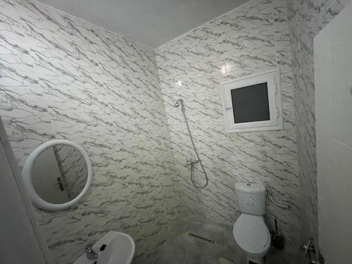 La salle de bains est pourvue d'un lavabo, d'un miroir et de toilettes. dans l'établissement DIaR MAHER, à Al Maqārisah