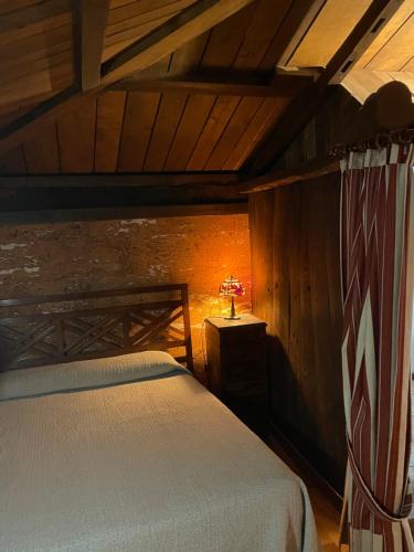 a bedroom with a bed and a lamp on a table at Casa rural en Redes in Ríoseco