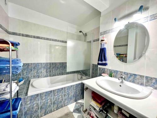 a bathroom with a sink and a tub and a mirror at A la campagne chez l'habitant in Germainville