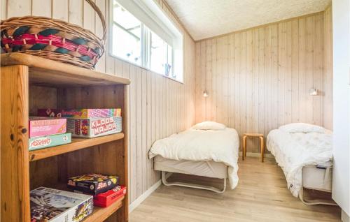 ÅrøsundにあるCozy Home In Haderslev With Wifiの小さなお部屋で、ベッド2台、本棚が備わります。