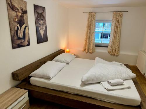 a bedroom with a bed with two pillows and a window at Familienparadies MoNi Ferienwohnung 17 in Thiersee