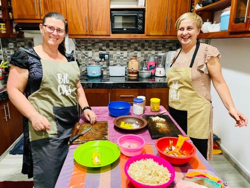 two women standing in a kitchen preparing food at Ambuluwawa View Inn in Gampola