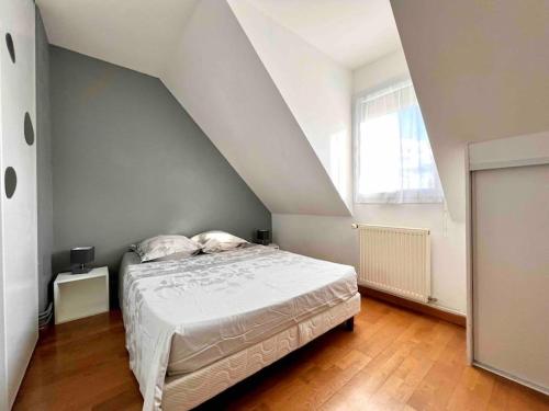 a white bedroom with a bed and a window at A la campagne chez l'habitant 