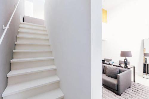 a staircase in a living room with a chair at The Dylan Amsterdam - The Leading Hotels of the World in Amsterdam
