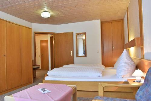 シュルッフゼーにあるHotel Hirschenのベッドルーム(白い大型ベッド1台、木製キャビネット付)
