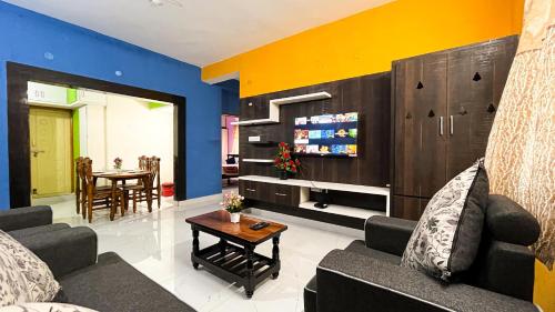 ein Wohnzimmer mit einem Sofa und einem Tisch in der Unterkunft S V IDEAL HOMESTAY -2BHK SERVICE APARTMENTS-AC Bedrooms, Premium Amities, Near to Airport in Tirupati