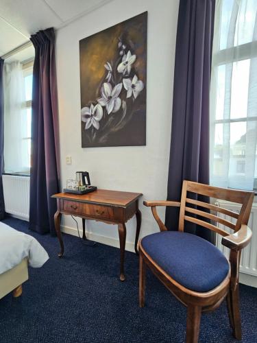 a room with a desk and a chair and a painting at Hotel 1711 in Valkenburg