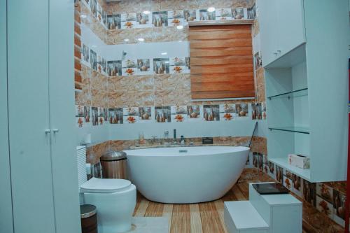 a bathroom with a large tub and a toilet at Family Home in Maroko