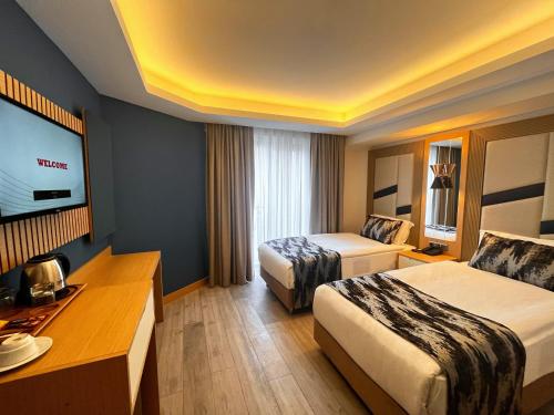 a hotel room with two beds and a flat screen tv at Downtown Sirkeci Hotel in Istanbul