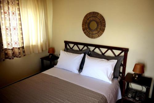 1 dormitorio con cama con almohadas blancas y espejo en Ocean Vista Retreat, en Skála