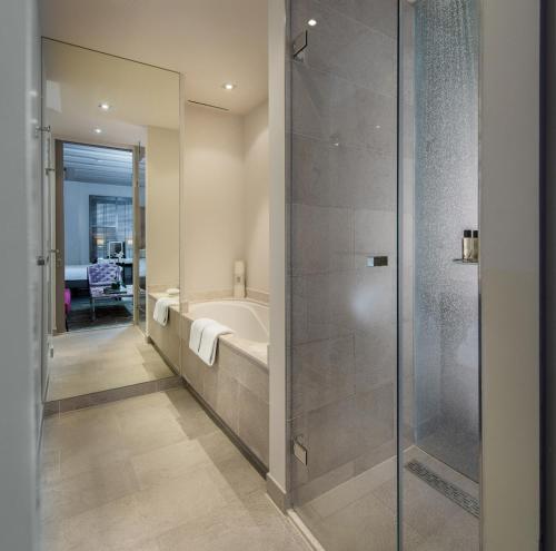 a bathroom with a bath tub and a shower stall at The Dylan Amsterdam - The Leading Hotels of the World in Amsterdam