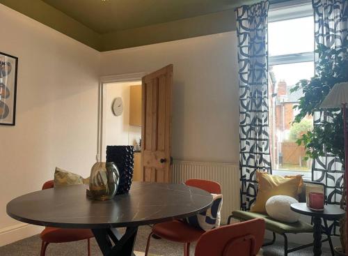 sala de estar con mesa, sillas y ventana en Coventry Lovely House, Sleeps 4, by Empower Homes en Coventry