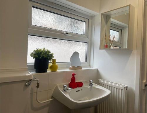 a bathroom with a sink and a window at Coventry Lovely House, Sleeps 4, by Empower Homes in Coventry