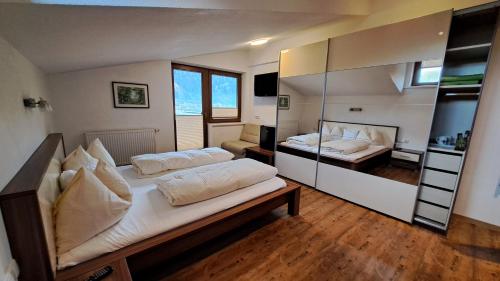 a bedroom with two beds and a mirror at Landhaus Rauch in Schwendau