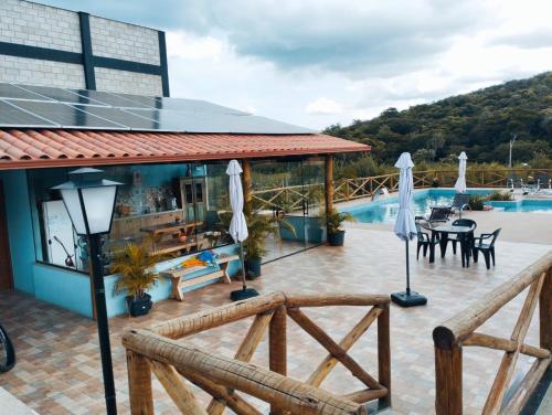 a resort with a pool and a patio with umbrellas at Pousada Quatro Estações in Santana do Riacho