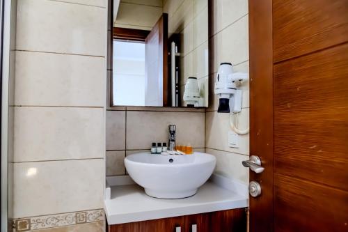 a bathroom with a white sink and a mirror at City Hall Apart Hotel Sultanahmet in Istanbul