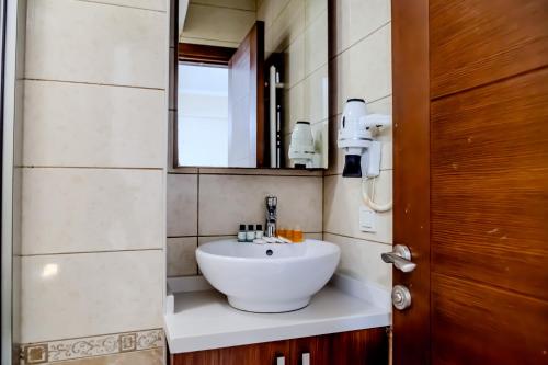 y baño con lavabo blanco y espejo. en City Hall Apart Hotel, en Estambul