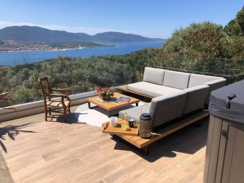 d'un canapé et d'une table sur une terrasse avec vue. dans l'établissement Maison avec jacuzzi, à Olmeto