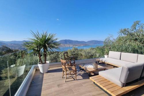 un patio avec un canapé, une table et des chaises dans l'établissement Maison avec jacuzzi, à Olmeto