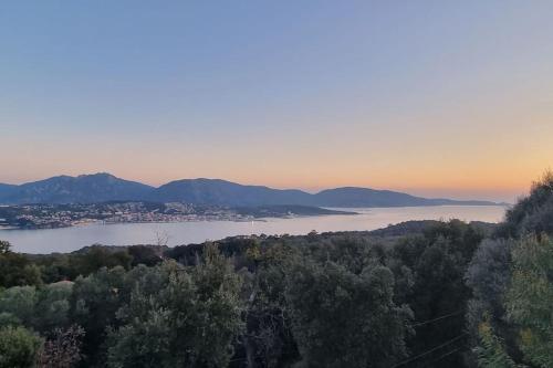 Elle offre une vue sur un lac avec une ville et des montagnes. dans l'établissement Maison avec jacuzzi, à Olmeto